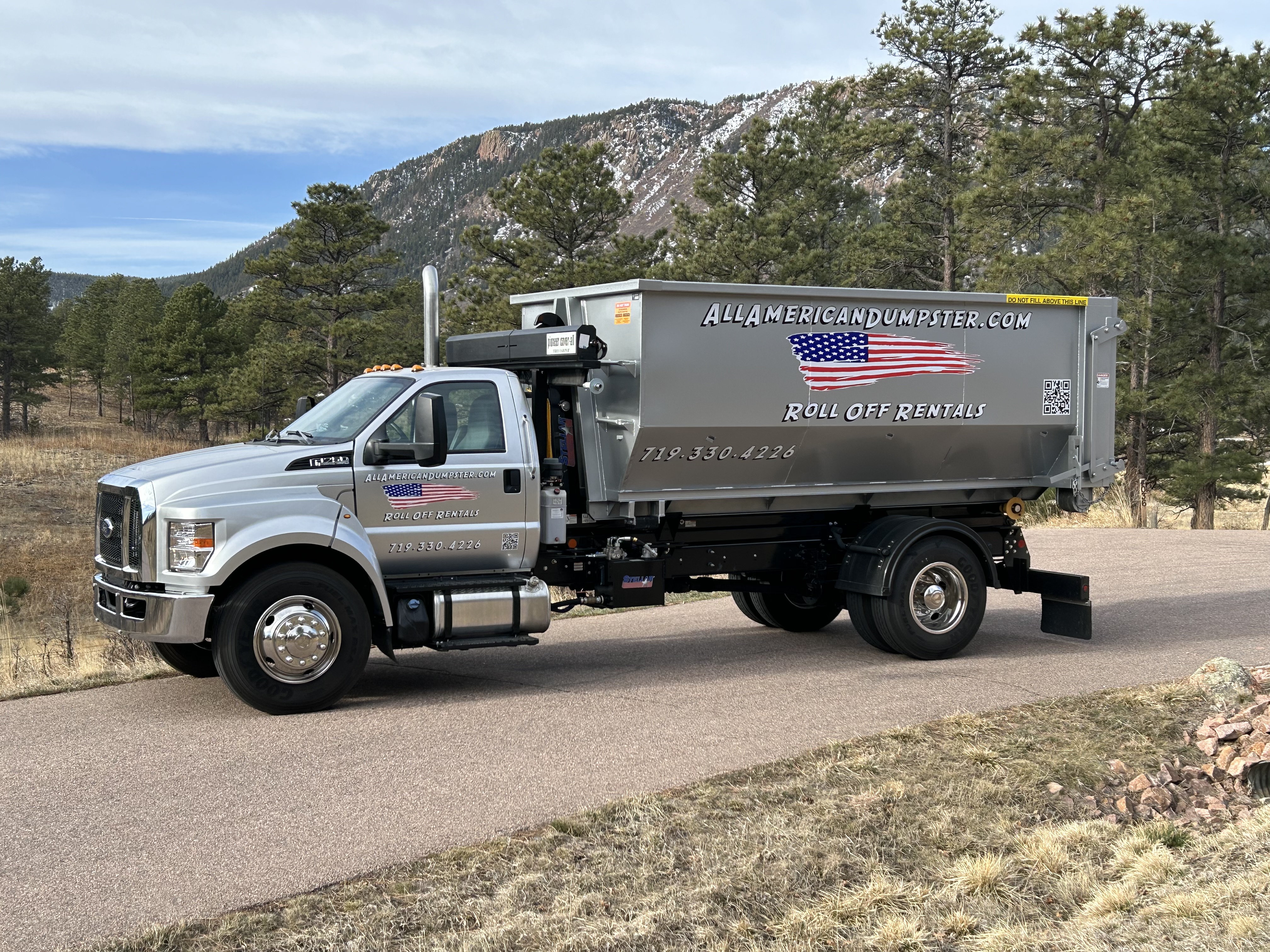 Roll-off dumpster truck with Colorado mountains